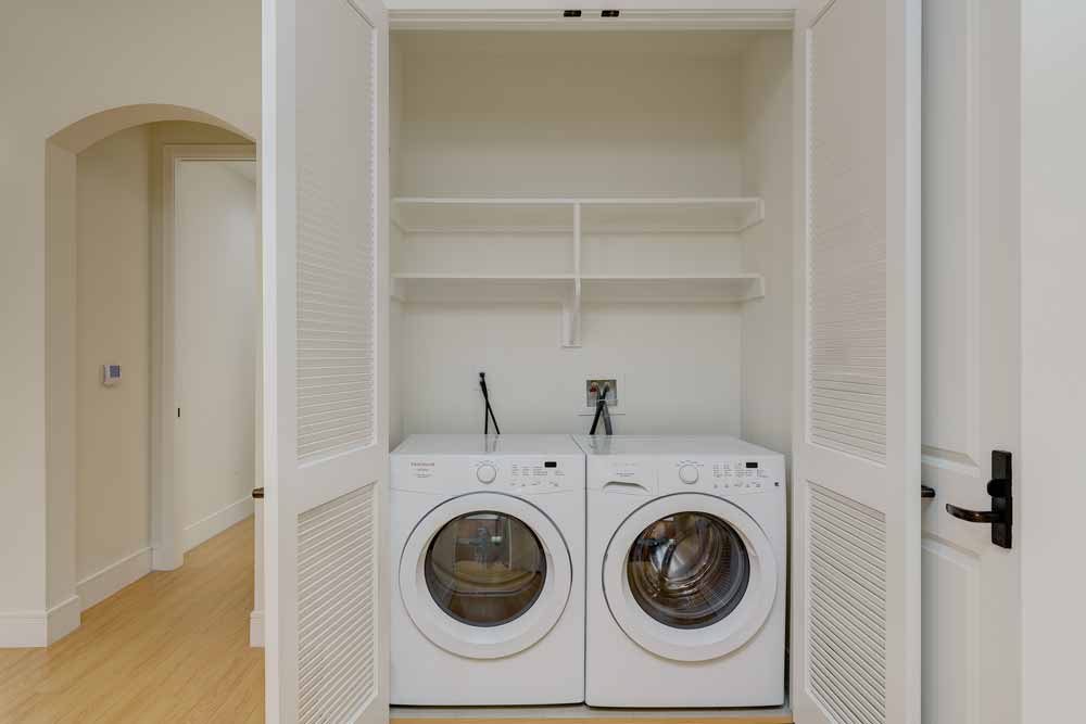 Picture of stacked washer and dryer in dedicated laundry closet.